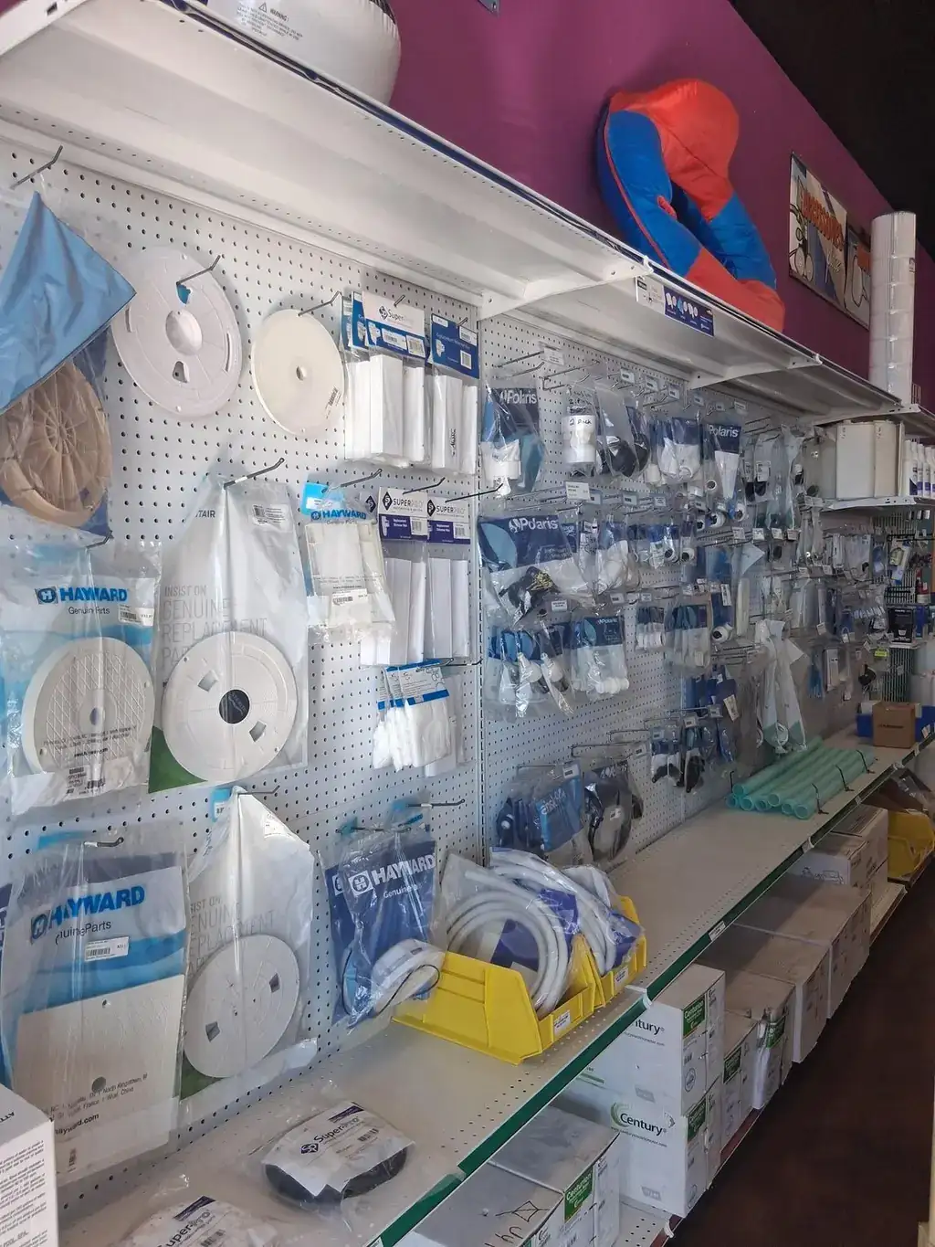 Parts wall inside the store stocked with Hayward and Pentair replacement parts, Polaris cleaner spares, and motors